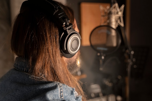 Uomo di vista laterale che canta in studio