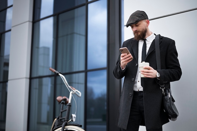 Uomo di vista laterale che controlla il telefono