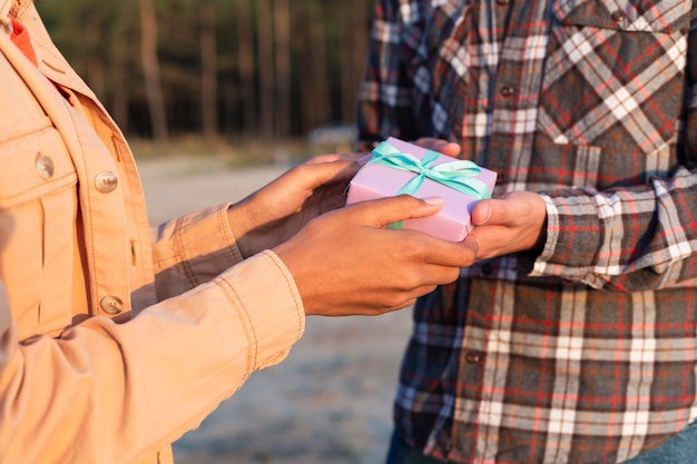 Uomo di vista laterale che dà alla sua ragazza un regalo avvolto