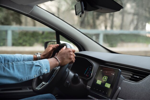 Uomo di vista laterale che guida un'auto elettrica