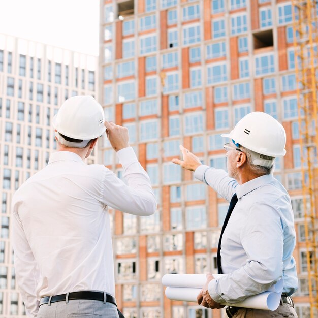 Uomo di vista laterale che indica all'armatura della costruzione