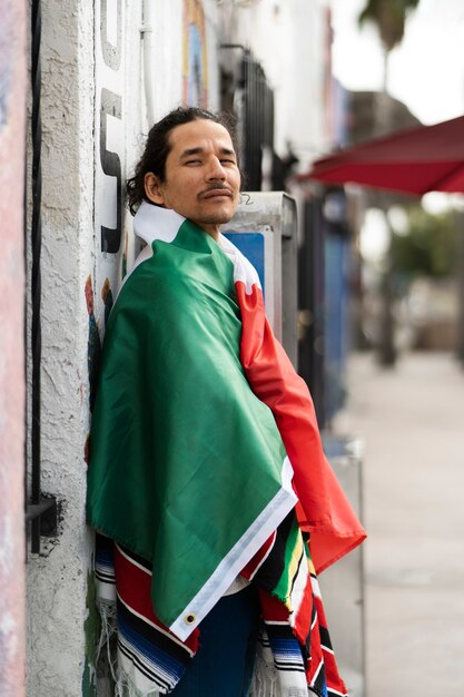 Uomo di vista laterale che indossa la bandiera messicana