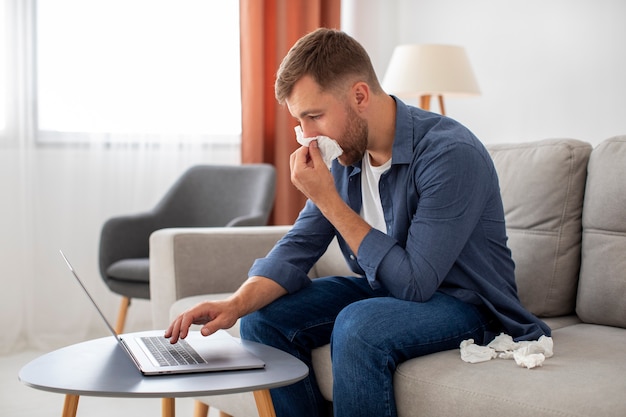 Uomo di vista laterale che lavora al computer portatile