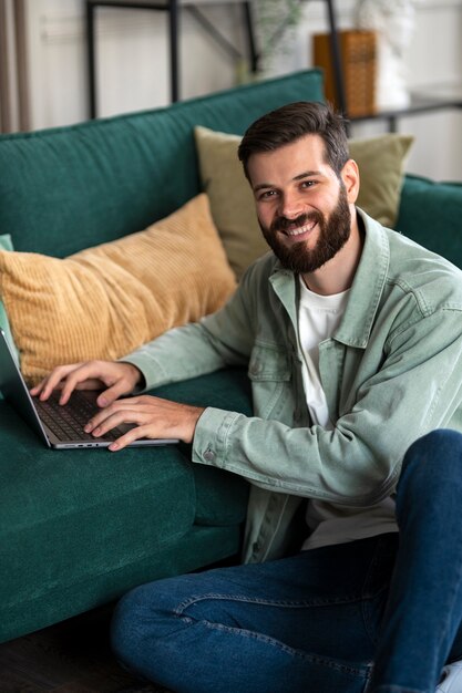Uomo di vista laterale che lavora al computer portatile