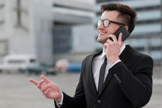 Uomo di vista laterale che parla sopra il telefono