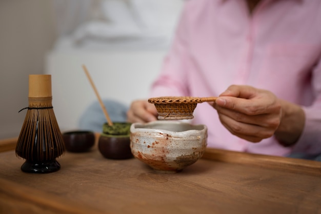 Uomo di vista laterale che prepara il tè matcha