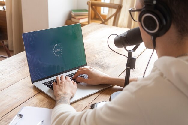 Uomo di vista laterale che scrive sul computer portatile