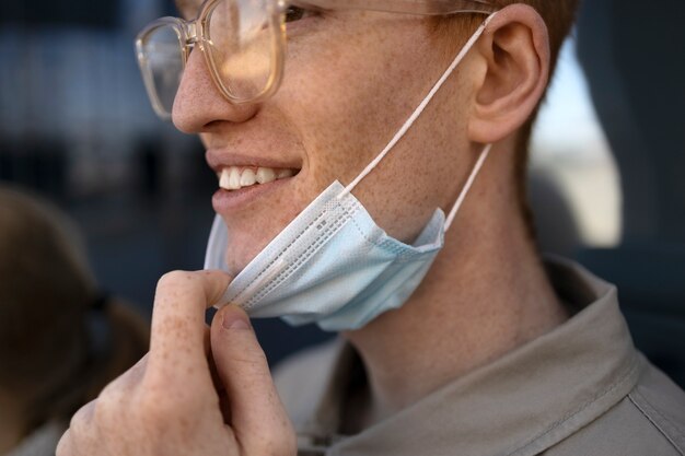 Uomo di vista laterale che si toglie la maschera