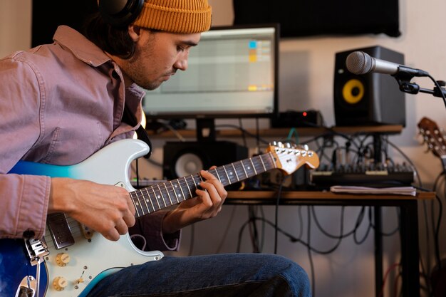 Uomo di vista laterale che suona la chitarra