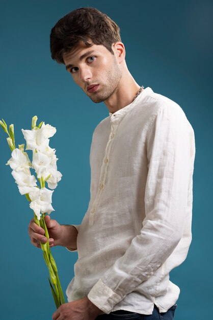 Uomo di vista laterale che tiene fiori bianchi