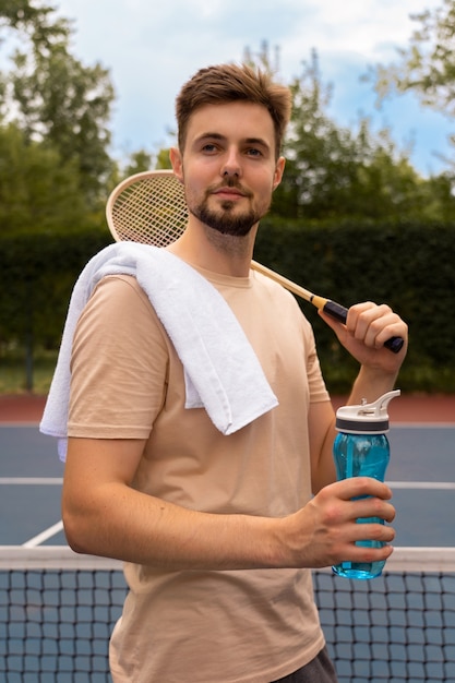 Uomo di vista laterale che tiene la racchetta di badminton