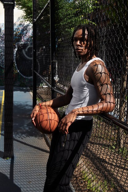 Uomo di vista laterale che tiene palla da basket