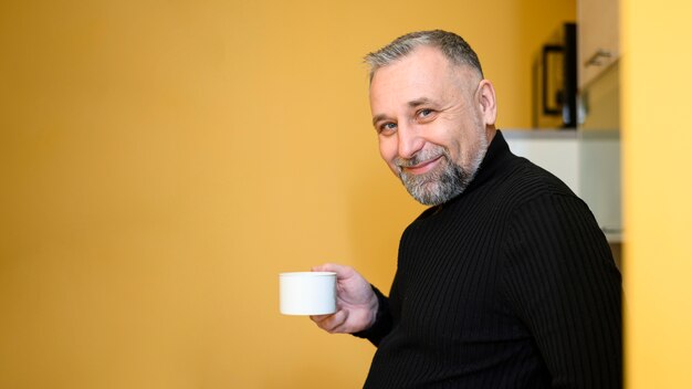 Uomo di vista laterale che tiene una tazza di tè