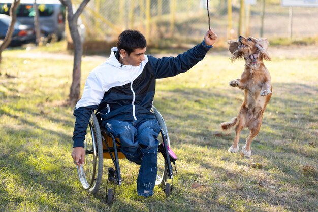 Uomo disabile del colpo pieno che gioca con il cane