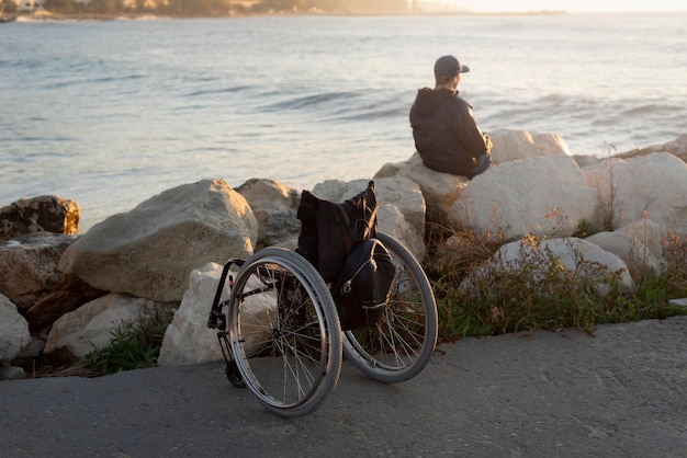 Uomo disabile del colpo pieno in riva al mare