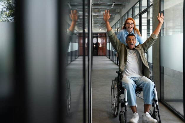 Uomo disabile su una sedia a rotelle che lavora nel suo lavoro d'ufficio