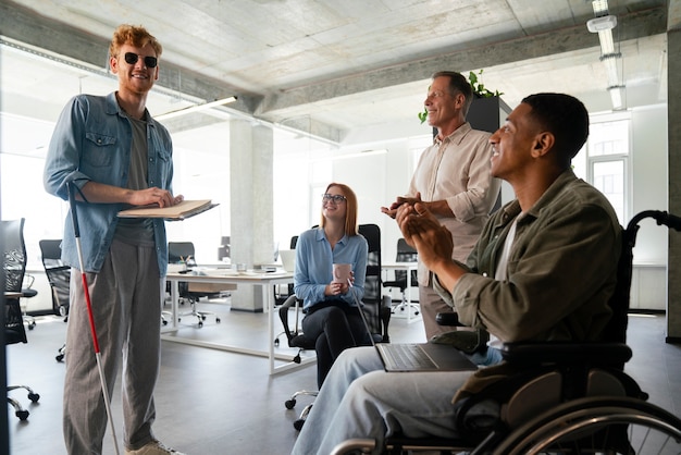 Uomo disabile su una sedia a rotelle che lavora nel suo lavoro d'ufficio