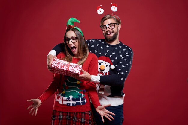 Uomo divertente che dà il regalo di Natale Coppia in piedi accanto al bastoncino di zucchero