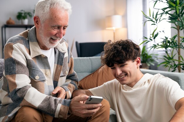 Uomo e adolescente di tiro medio con smartphone