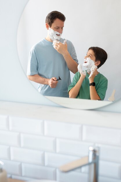 Uomo e bambino sorridente di vista frontale con crema da barba