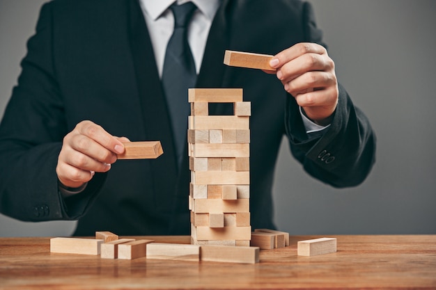 Uomo e cubi di legno sul tavolo. Concetto di gestione