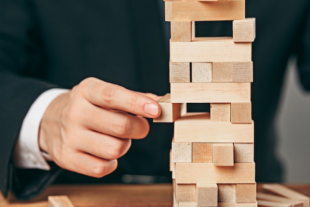 Uomo e cubi di legno sul tavolo. Concetto di gestione