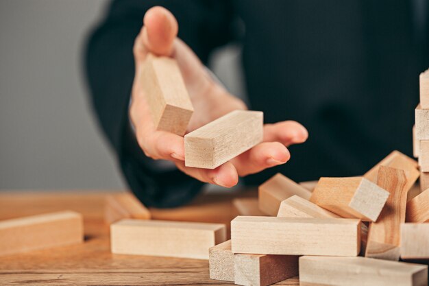 Uomo e cubi di legno sul tavolo. Concetto di gestione