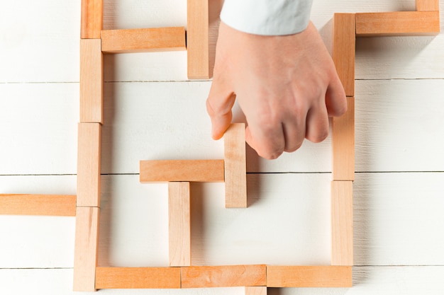 Uomo e cubi di legno sul tavolo. Concetto di gestione