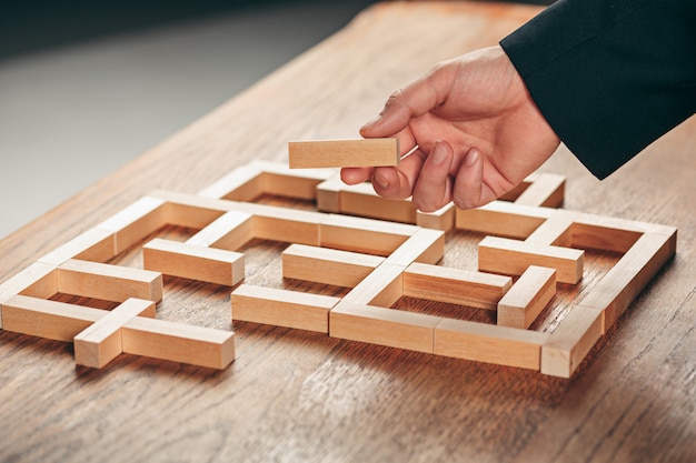 Uomo e cubi di legno sul tavolo. Concetto di gestione