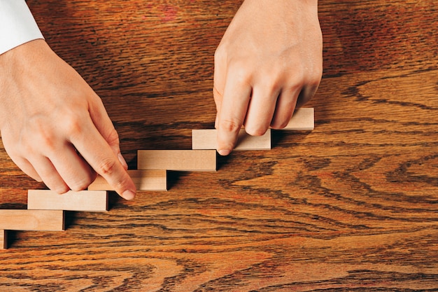 Uomo e cubi di legno sul tavolo. Concetto di gestione