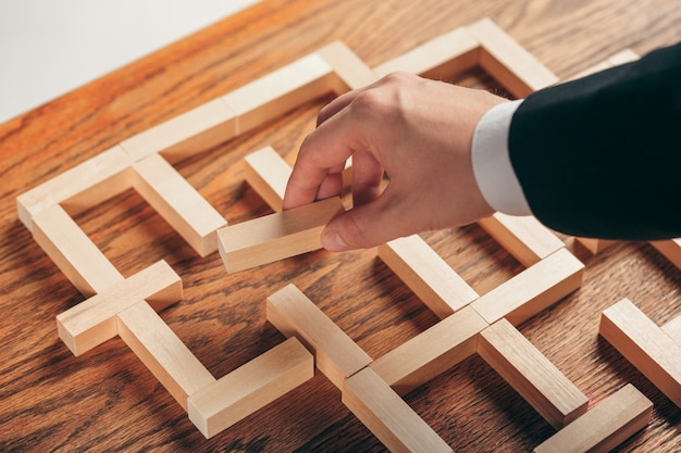 Uomo e cubi di legno sul tavolo. Concetto di gestione