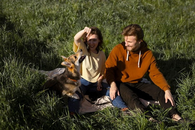 Uomo e donna a tutto campo con un cane carino