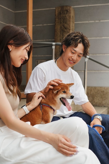 Uomo e donna asiatici con il loro cane shiba inu all'aperto