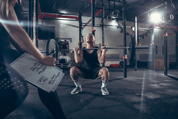 Uomo e donna atletici con le teste di legno