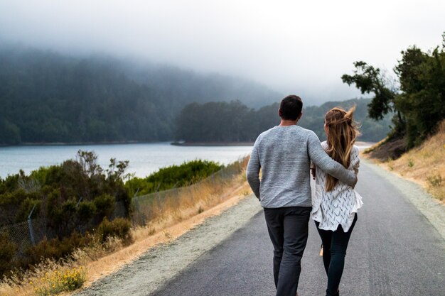 Uomo e donna che camminano sulla strada asfaltata