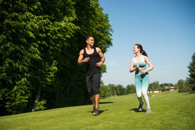 Uomo e donna che corrono all&#39;aperto in un parco