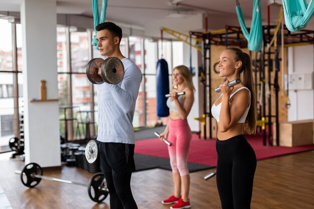 Uomo e donna che fanno allenamento con i pesi