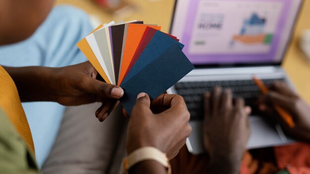 Uomo e donna che fanno progetti per ristrutturare casa utilizzando la tavolozza dei colori e il laptop