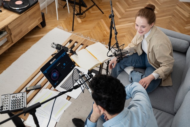 Uomo e donna che gestiscono insieme un podcast in studio