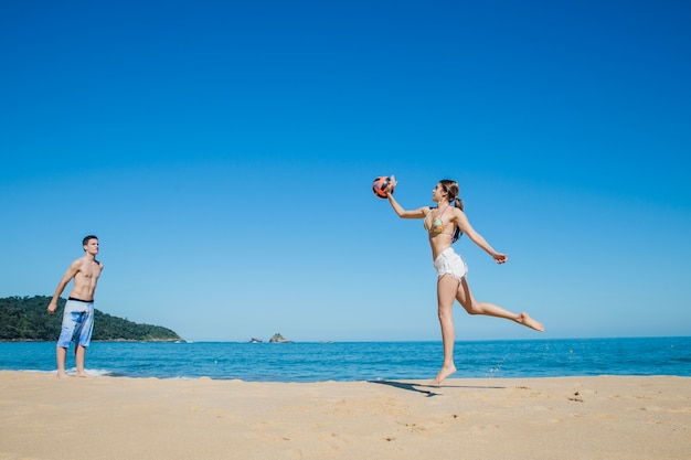 Uomo e donna che giocano a beach volley