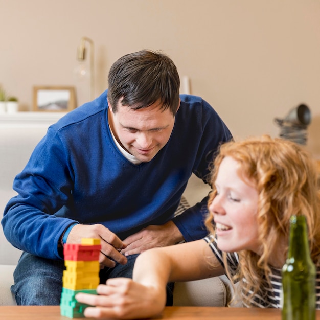 Uomo e donna che giocano a casa mentre bevono birra