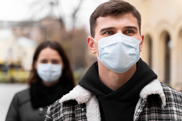 Uomo e donna che indossano maschere mediche