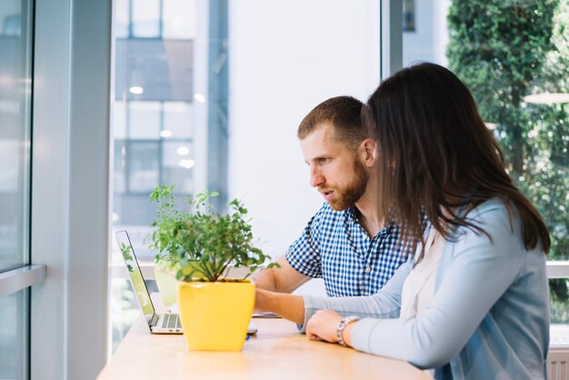 Uomo e donna che lavorano vicino a piante in vaso