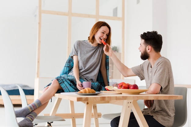 Uomo e donna che mangiano in cucina