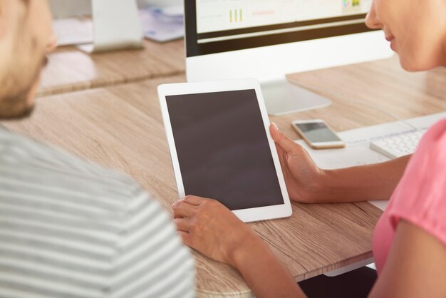 Uomo e donna che passano in rassegna la tavoletta digitale