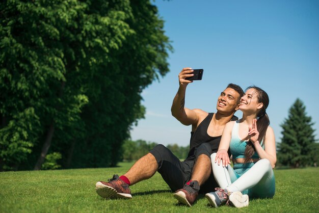Uomo e donna che prendono un selfie in un parco