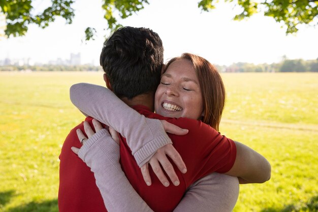 Uomo e donna che si abbracciano prima di fare yoga all'aperto