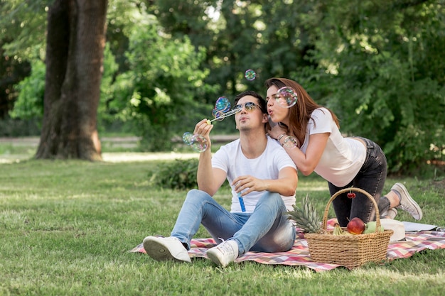 Uomo e donna che si divertono facendo bolle