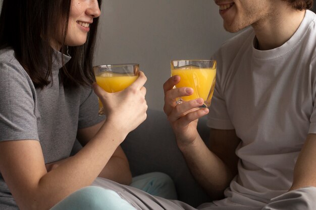 Uomo e donna che sorridono e che tengono il succo di arancia
