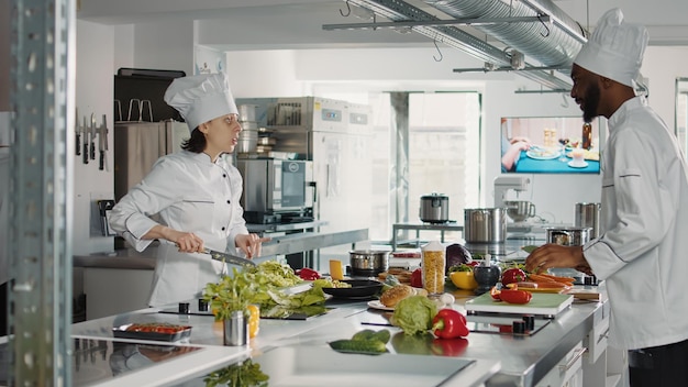 Uomo e donna che tagliano gli ingredienti freschi per fare un piatto gourmet